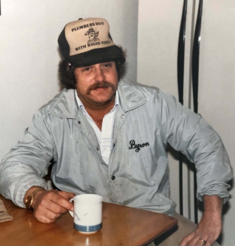 Byron R. Vile Sr. during the early years of Byron’s Plumbing and Heating, wearing his embroidered work jacket and plumber hat.